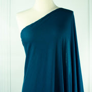 Italian Viscose Tissue Jersey designer deadstock fabric by the yard. Enjoy a bit of high-end designer British luxury! Casual, elegant, and soft, this tissue jersey has a lovely drape, thin hand, and is light and translucent. Perfect for a dress, loungewear, or T-Shirt or layering piece. Image of fabric draped on dressform.