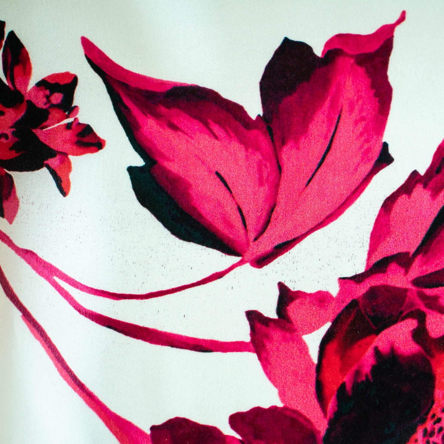 Italian Floral Silk satin designer deadstock fabric by the yard. Ready to create something gorgeous with our silk satin fabric of red and pink blooms highlighted by a bit of black for drama set against a white background. This thin woven silk from the Italian mills has a smooth satiny hand and just the right amount of flow! Image of fabric printing defect.