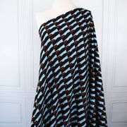 Italian Geometric Poly Satin designer deadstock fabric by the yard. From the Italian mills, a gorgeous satin with a modern palette of light blue, earthy brown and black that will elevate your next sewing project!  Long image of fabric draped on dressform.