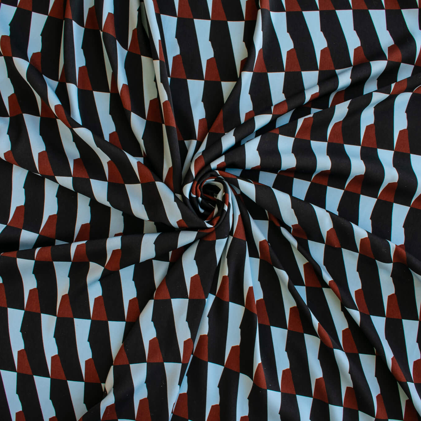Italian Geometric Poly Satin designer deadstock fabric by the yard. From the Italian mills, a gorgeous satin with a modern palette of light blue, earthy brown and black that will elevate your next sewing project! Image of fabric fullness.
