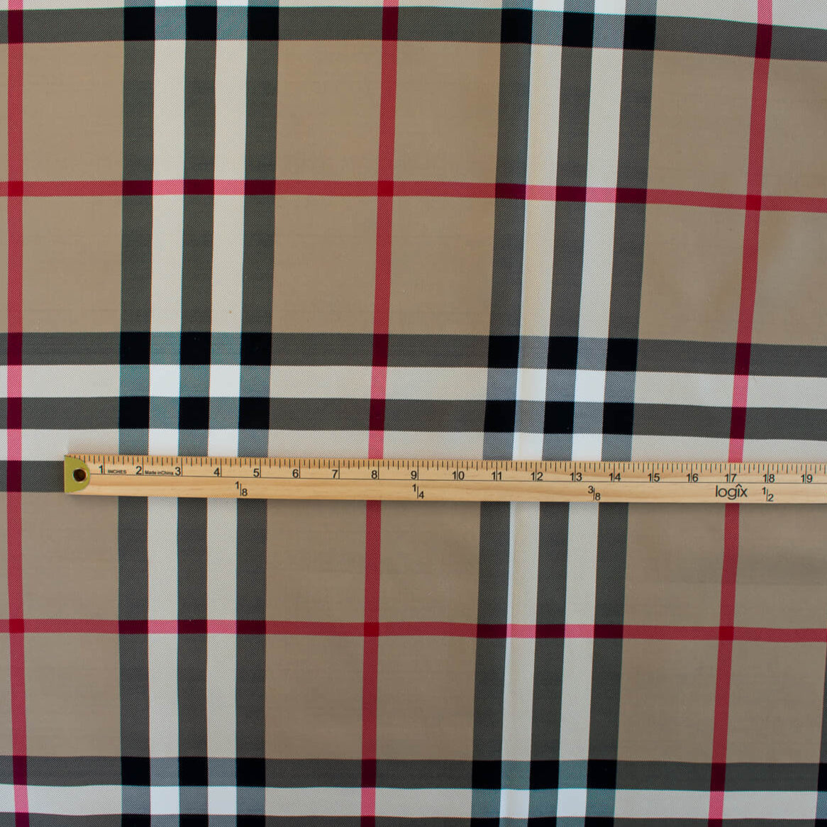 Couture British Designer Plaid Scuba Knit designer deadstock fabric by the yard. Bring on that London Style, in a classic plaid with a bit of a twist...it's scuba! Image of fabric design with ruler.