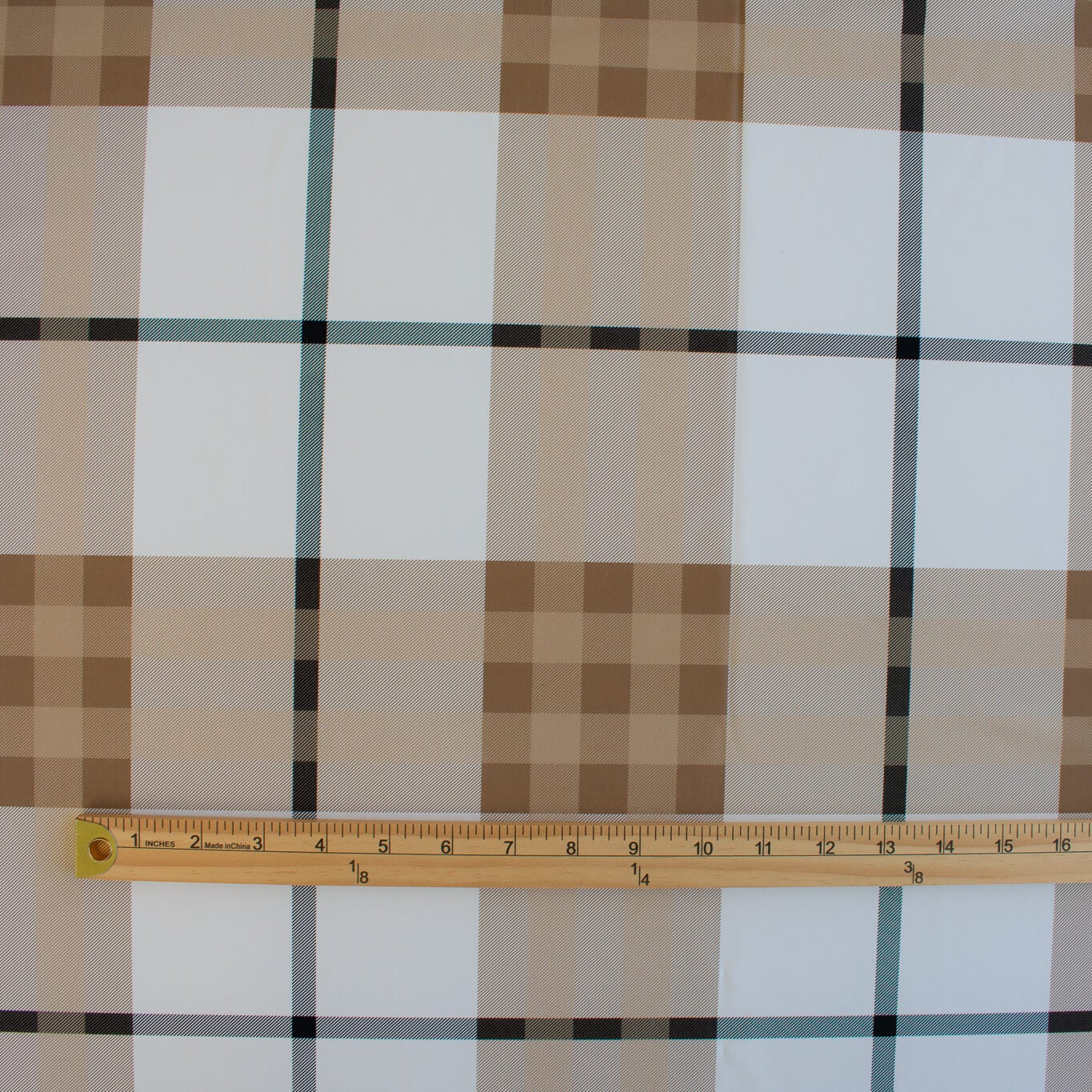 Couture British Designer Plaid Knit designer deadstock fabric by the yard. Bring on that London Style, in a knit! If you are looking to sew up some resort pieces this season then this is your knit. The cool sleek hand and drape of this fabric is perfect for swimwear, coverups, tops and cute dresses and skirts. Image of fabric design scale with ruler.