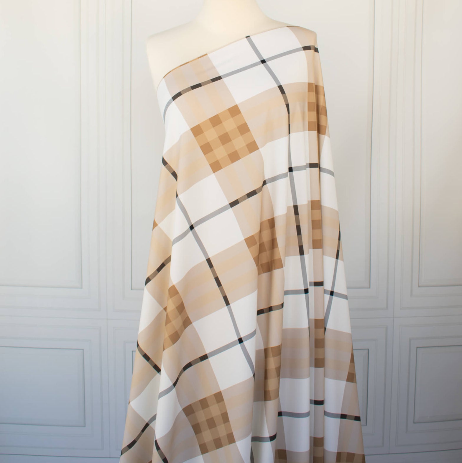 Couture British Designer Plaid Knit designer deadstock fabric by the yard. Bring on that London Style, in a knit! If you are looking to sew up some resort pieces this season then this is your knit. The cool sleek hand and drape of this fabric is perfect for swimwear, coverups, tops and cute dresses and skirts. Image of fabric draped on dressform.