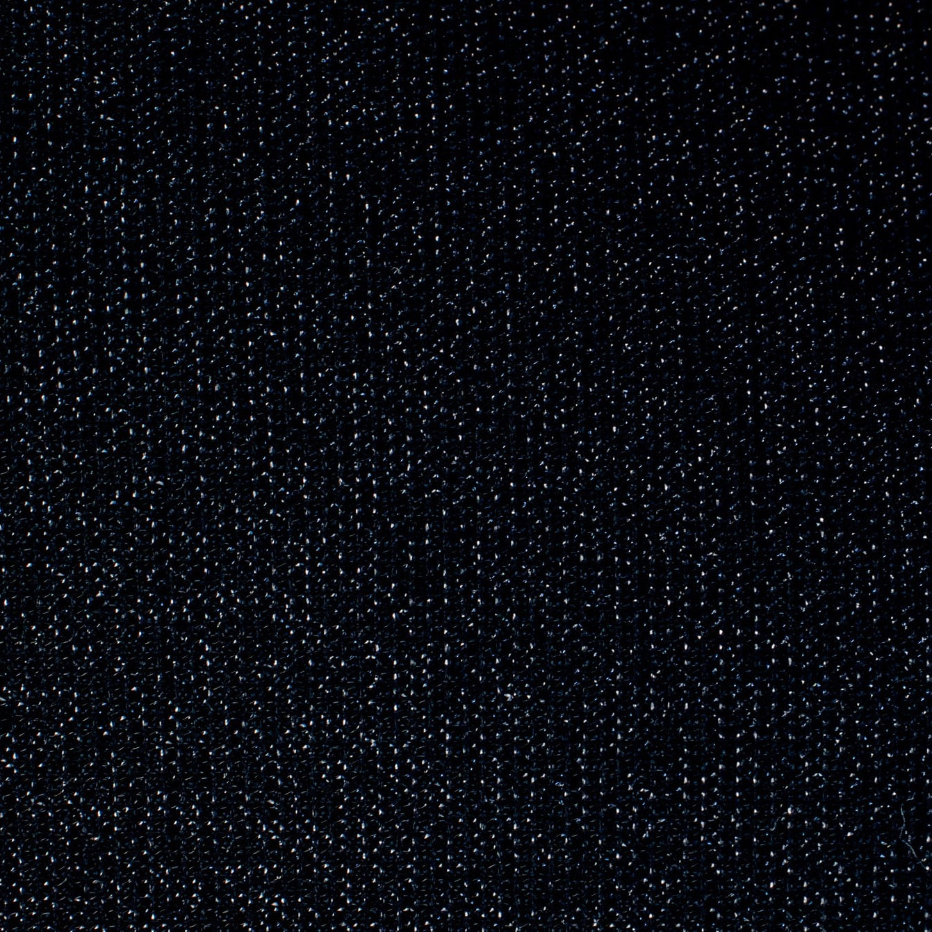 Feel glamorous with our Designer Shimmer Black Sweater Knit fabric by the yard - 'Fancy This'. This high-end designer deadstock knit in classic black with the perfect touch of sparkle. Soft and comfortable, this sweater is sure to become one of your favorite fashion staples. Close up image of fabric