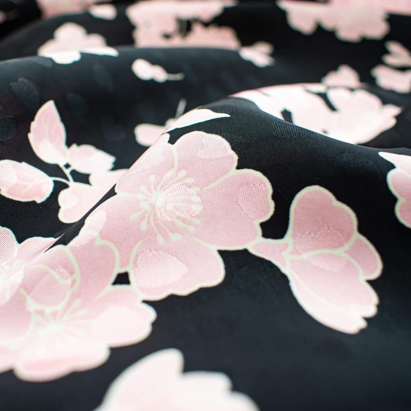 Couture Italian Viscose Floral Jacquard - 'All My Heart'! This stunning designer deadstock fabric by the yard features a gorgeous black base with delicate pink florals and ivory accents. Plus, playful and trending jacquard hearts add a touch of whimsy. 
Featuring a nice drape that falls away from the body and slightly textured hand, you'll find this fabric is perfect for formal attire or a little something special.  Close up image of fabric detail to include jacquard pattern.