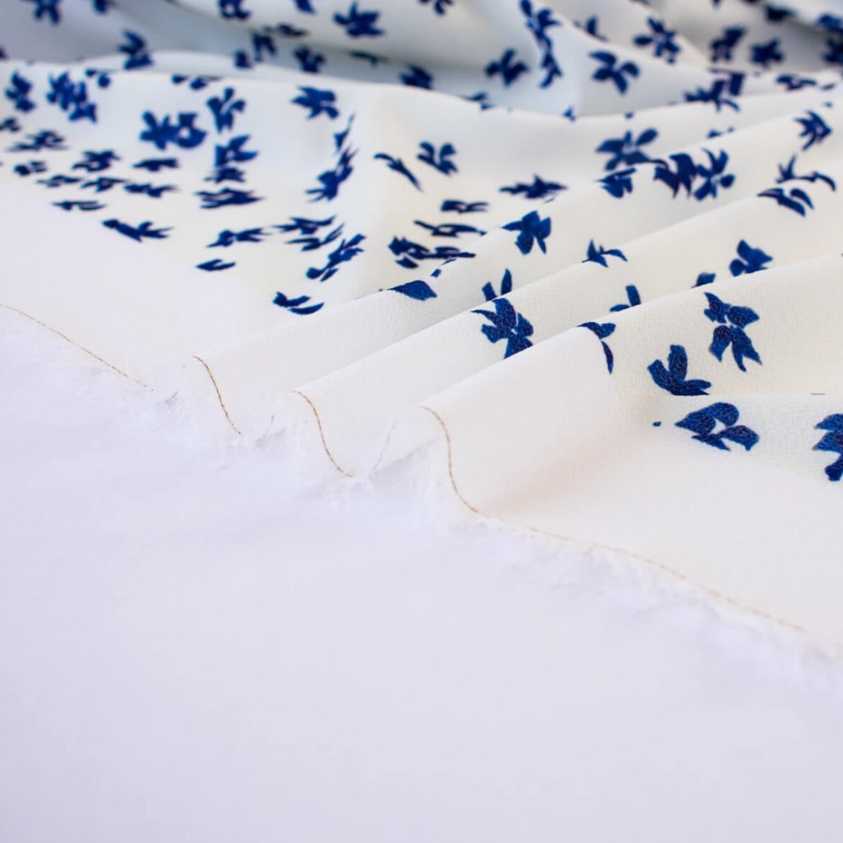 Image of selvedge. Couture, Italian, blue and white floral crepe deadstock fabric by the yard. Sourced from a Los Angeles designer of ready-to-wear and bridal pieces and a favorite among some of Hollywoods A-List stars!