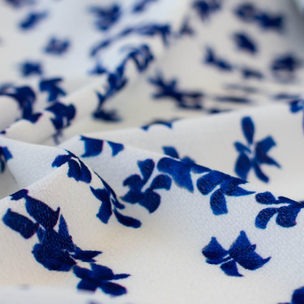 Close up image. Couture, Italian, blue and white floral crepe deadstock fabric by the yard. Sourced from a Los Angeles designer of ready-to-wear and bridal pieces and a favorite among some of Hollywoods A-List stars!