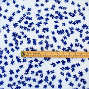 Image of fabric design with ruler for scale. Couture, Italian, blue and white floral crepe deadstock fabric by the yard. Sourced from a Los Angeles designer of ready-to-wear and bridal pieces and a favorite among some of Hollywoods A-List stars!