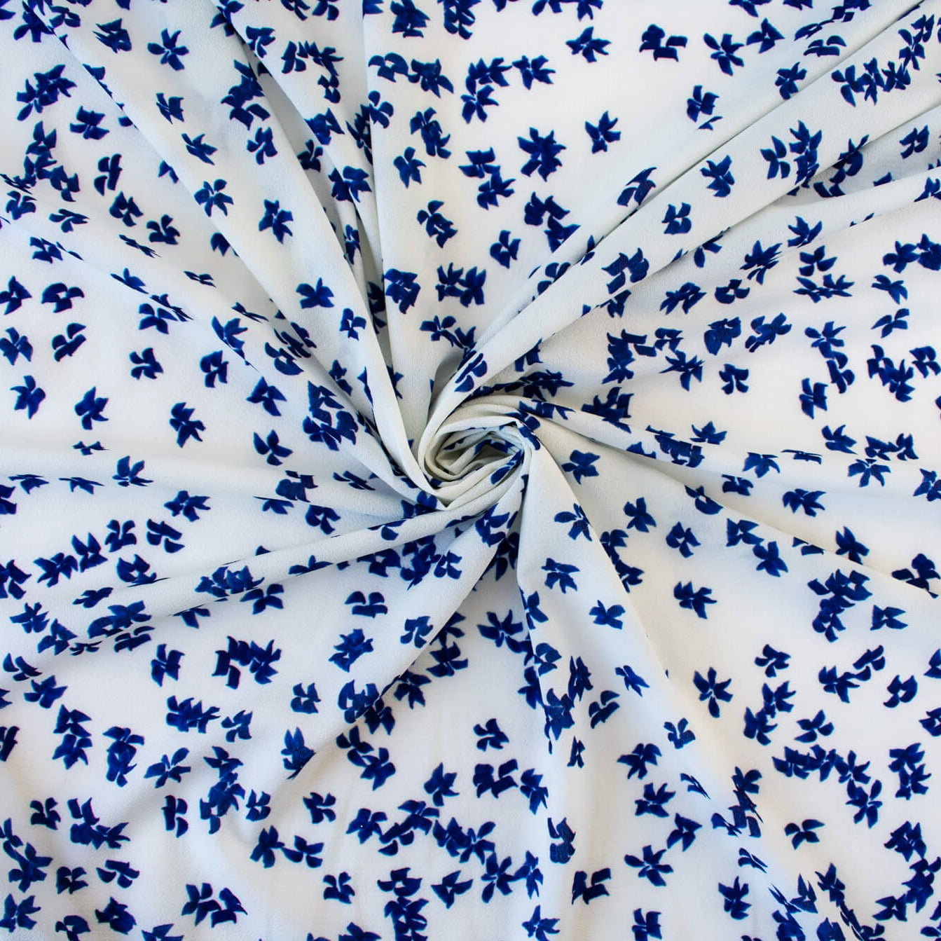 Image of fabric body. Couture, Italian, blue and white floral crepe deadstock fabric by the yard. Sourced from a Los Angeles designer of ready-to-wear and bridal pieces and a favorite among some of Hollywoods A-List stars!
