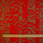 Italian Single Viscose Jersey Red and Caramel Modern Print fabric by the yard. A gorgeous vibrant knit that is sure to capture compliments. We love this combination of red and caramel brown tones in this modern jersey knit fabric. The printed design has a bit of animal print edge in a stripe like pattern.  Image of fabric design scale with ruler.
