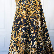Italian Animal Print Wool Blend Jersey knit fabric by the yard. Shades of gold and cream flow against dramatic coal a bits of blue to create a vibrant and sophisticated animal print design. This would make a lovely wrap style long cardigan, a bold fitted sheath dress, or pencil skirt. Image of fabric drape.