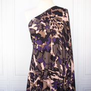 Italian Modern Floral Single Jersey Wool blend fabric by the yard. Gorgeous modern floral print perfect for transitioning to warmer months. This wool blend jersey in shades of brown, light pink, purple and black has a soft hand a beautiful drape. Whether you are creating a T-shirt or something a bit fancier, you're going to love how this fabric feels against your skin. Image of fabric draped on dressform.