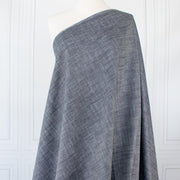 Stay cool and look amazing while you enjoy the breathability and sustainability of Tencel and all you love about linen in one gorgeous dark indigo fabric.   On the lighter side of a mid-weight with a beautiful sheen, nice drape, and softly textured hand you'll look 'Tres Chic'!  Vertical image of fabric draped on dressform.