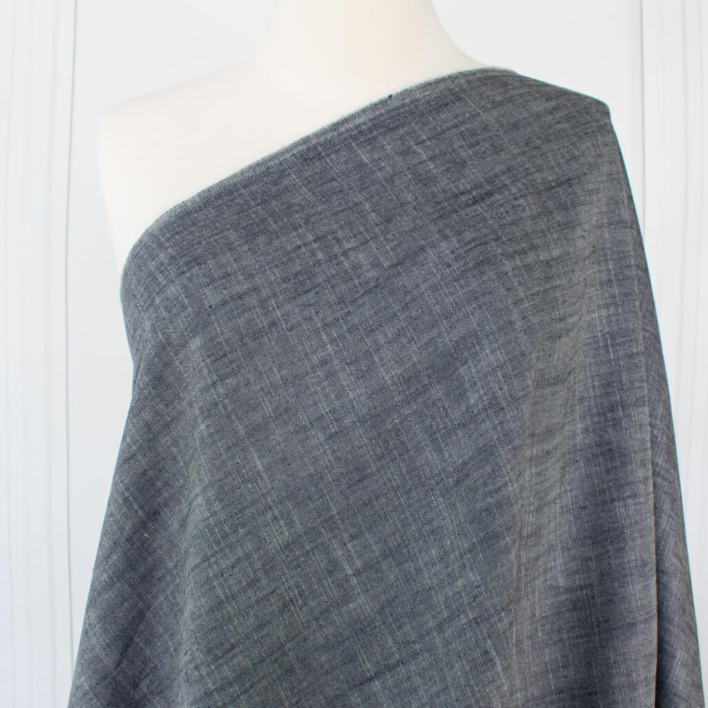 Stay cool and look amazing while you enjoy the breathability and sustainability of Tencel and all you love about linen in one gorgeous dark indigo fabric.   On the lighter side of a mid-weight with a beautiful sheen, nice drape, and softly textured hand you'll look 'Tres Chic'!  Image of fabric draped on dressform.