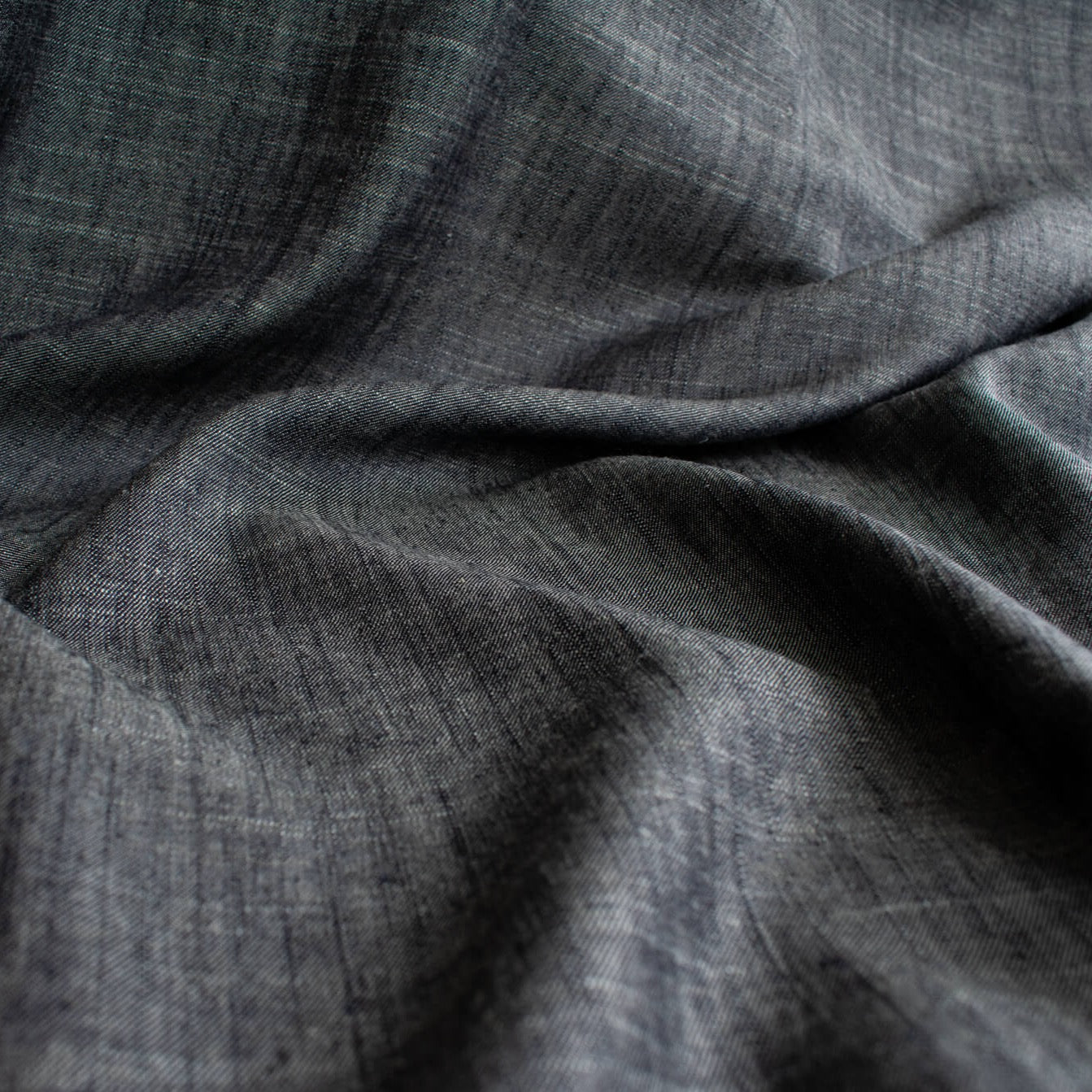 Stay cool and look amazing while you enjoy the breathability and sustainability of Tencel and all you love about linen in one gorgeous dark indigo fabric.   On the lighter side of a mid-weight with a beautiful sheen, nice drape, and softly textured hand you'll look 'Tres Chic'!  Close up image.