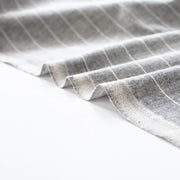 Cotton/Linen Chambray fabric by the yard. On the lighter side of mid-weight, this woven dark navy chambray features a white vertical pinstripe, a nice comfortable hand, and a lovely drape. Image of fabric selvedge
