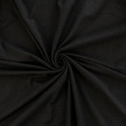 NYC High-End Designer Black Cotton Jersey Knit fabric by the yard. This deadstock fabric is the perfect sustainable choice for creating soft, flowy pieces that are both stylish and playful. It has a soft hand and translucent quality, and the extra wide width allows for versatile designs. Image of fabric fullness.