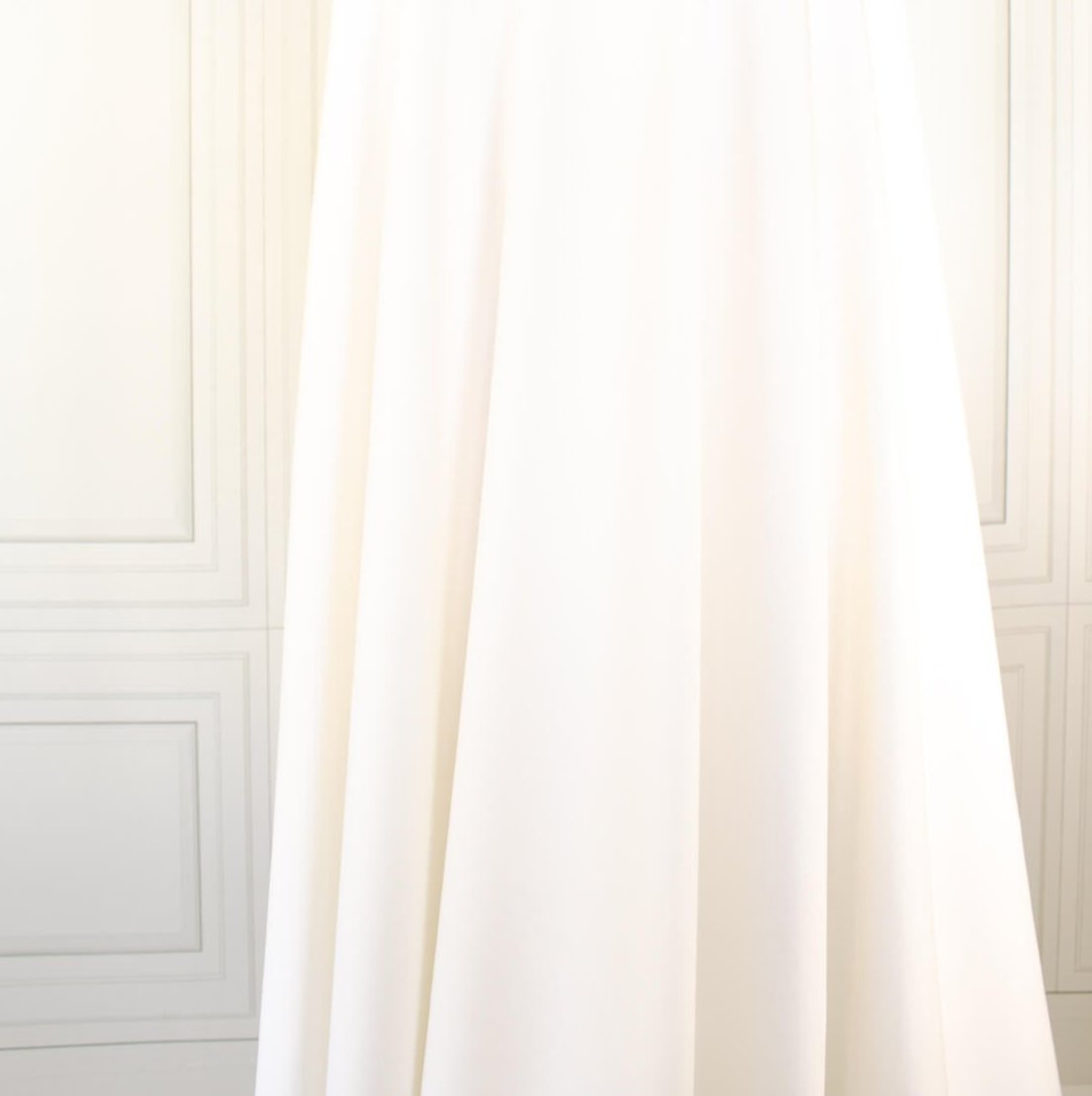 High-End Designer Pearl White Ponte Knit fabric by the yard. This Los Angeles designer has a knack for finding quality fabrics. This designer deadstock Ponte is soft with a nice drape that falls moderately close to the body. You'll fall in love with the comfort! Image of fabric drape.