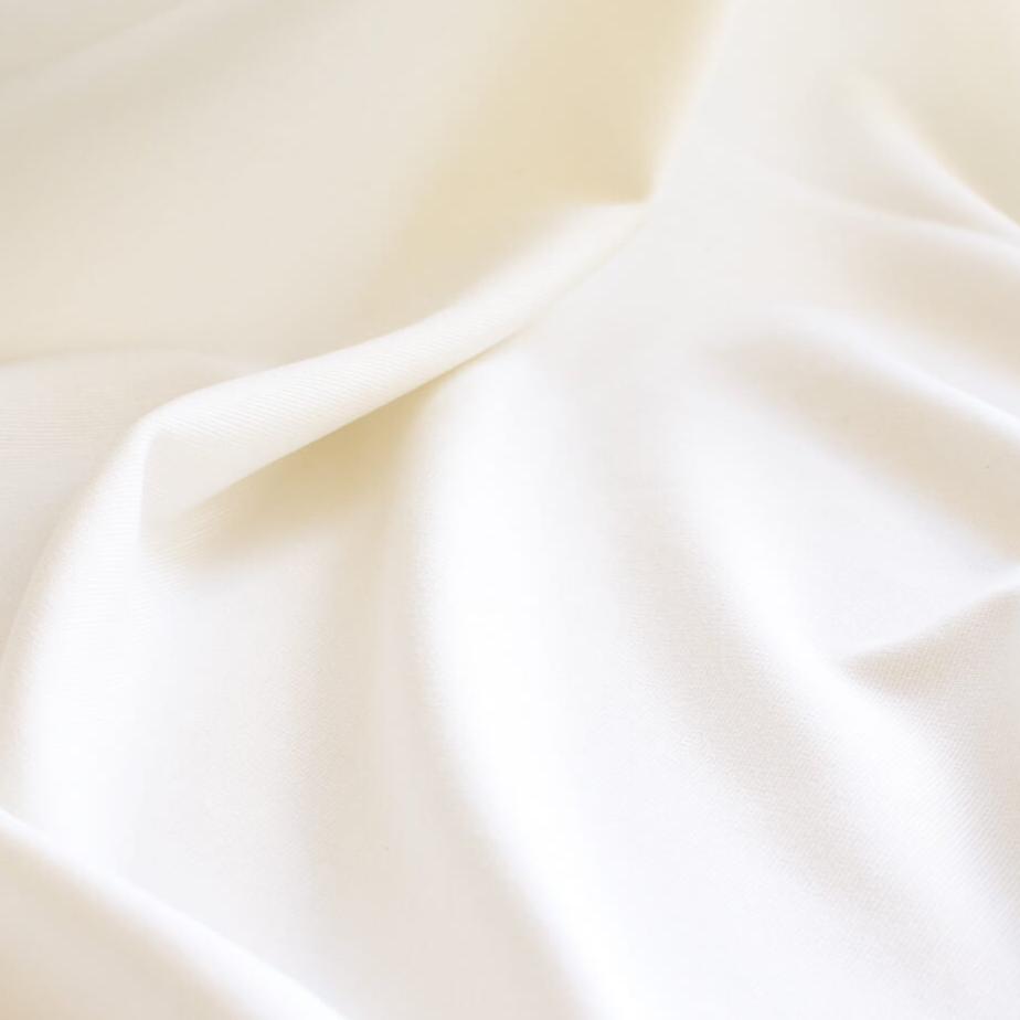 High-End Designer Pearl White Ponte Knit fabric by the yard. This Los Angeles designer has a knack for finding quality fabrics. This designer deadstock Ponte is soft with a nice drape that falls moderately close to the body. You'll fall in love with the comfort! Close up image.