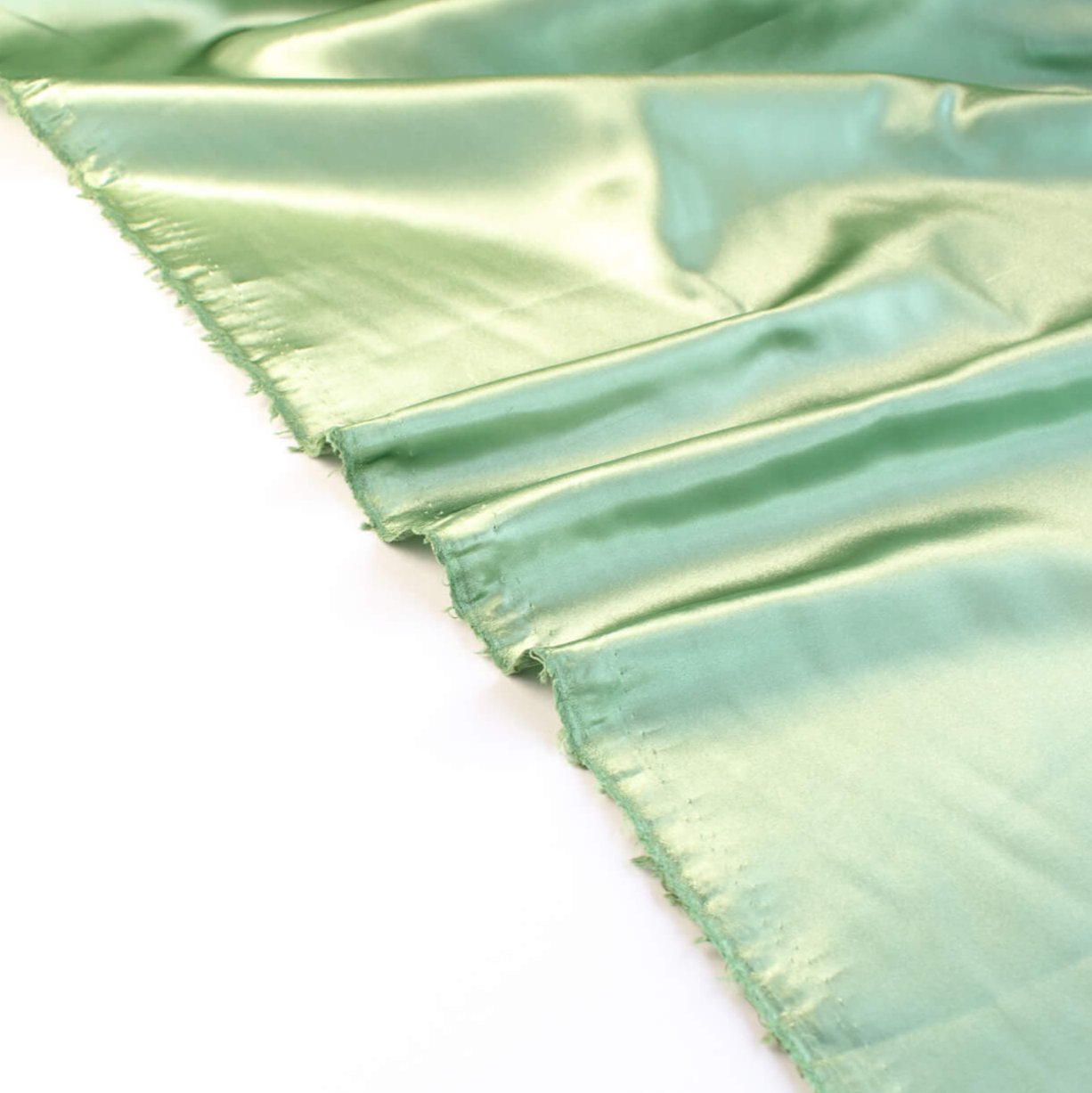 NYC Designer Polyester Satin designer deadstock fabric by the yard. Shimmery satin in a serene spring green is sophisticated and eye catching!  This opaque, tightly woven fabric falls moderately away from the body. Image of selvedge.