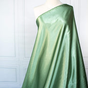 NYC Designer Polyester Satin designer deadstock fabric by the yard. Shimmery satin in a serene spring green is sophisticated and eye catching!  This opaque, tightly woven fabric falls moderately away from the body. Image of fabric drape.