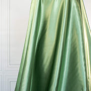 NYC Designer Polyester Satin designer deadstock fabric by the yard. Shimmery satin in a serene spring green is sophisticated and eye catching!  This opaque, tightly woven fabric falls moderately away from the body. Image of fabric drape.