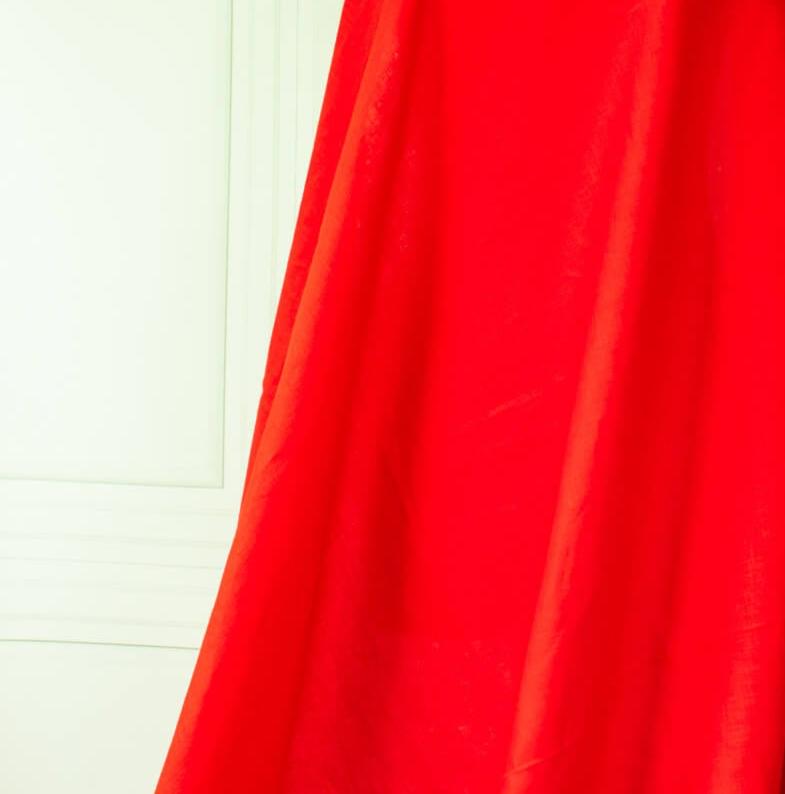 Red mid-weight linen fabric by the yard is just plain gorgeous. The fabric has a soft hand, slight slubbing, and the mid-weight makes it a perfect choice for tailored garments such as jackets and fitted sheath dresses or suitings.Close up image of fabric drape.