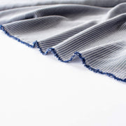 NYC Designer Deadstock Cotton Voile fabric by the yard. Amazingly soft and silky, this Navy/White horizontal stripe voile is lightweight with a thin hand, a must for warmer temperatures. Image of fabric selvedge.
