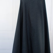 NYC Designer Dark Navy/White Striped Cotton/Spandex Shirting fabric by the yard in a midnight blue is a perfect staple when building your wardrobe pieces. This designer deadstock fabric boasts a soft and smooth hand, is tightly woven and enhanced with a touch of stretch.  Image of fabric drape reflecting how it will fall on the body.