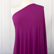 Designer ITY Solid Jersey Knit designer deadstock fabric by the yard. Perfect for travelwear, this ITY is universally flattering in a gorgeous light Orchid purple color. Close up image of fabric on dressform.