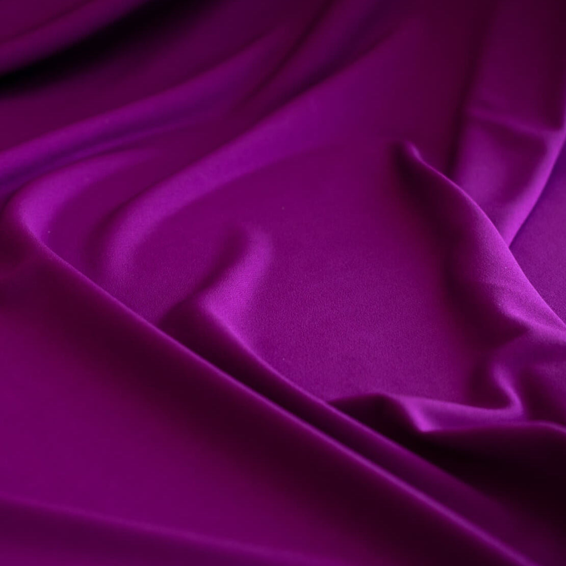 Designer ITY Solid Jersey Knit designer deadstock fabric by the yard. Perfect for travelwear, this ITY is universally flattering in a gorgeous light Orchid purple color. Close up image.