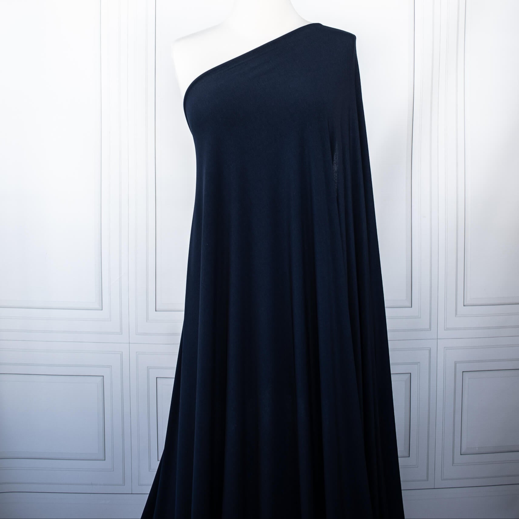 Designer ITY Solid Jersey Knit designer deadstock fabric by the yard. Perfect for travelwear, this ITY is sophisticated and elegant. The perfect choice for your next sewing project. Image of fabric drape on dressform.