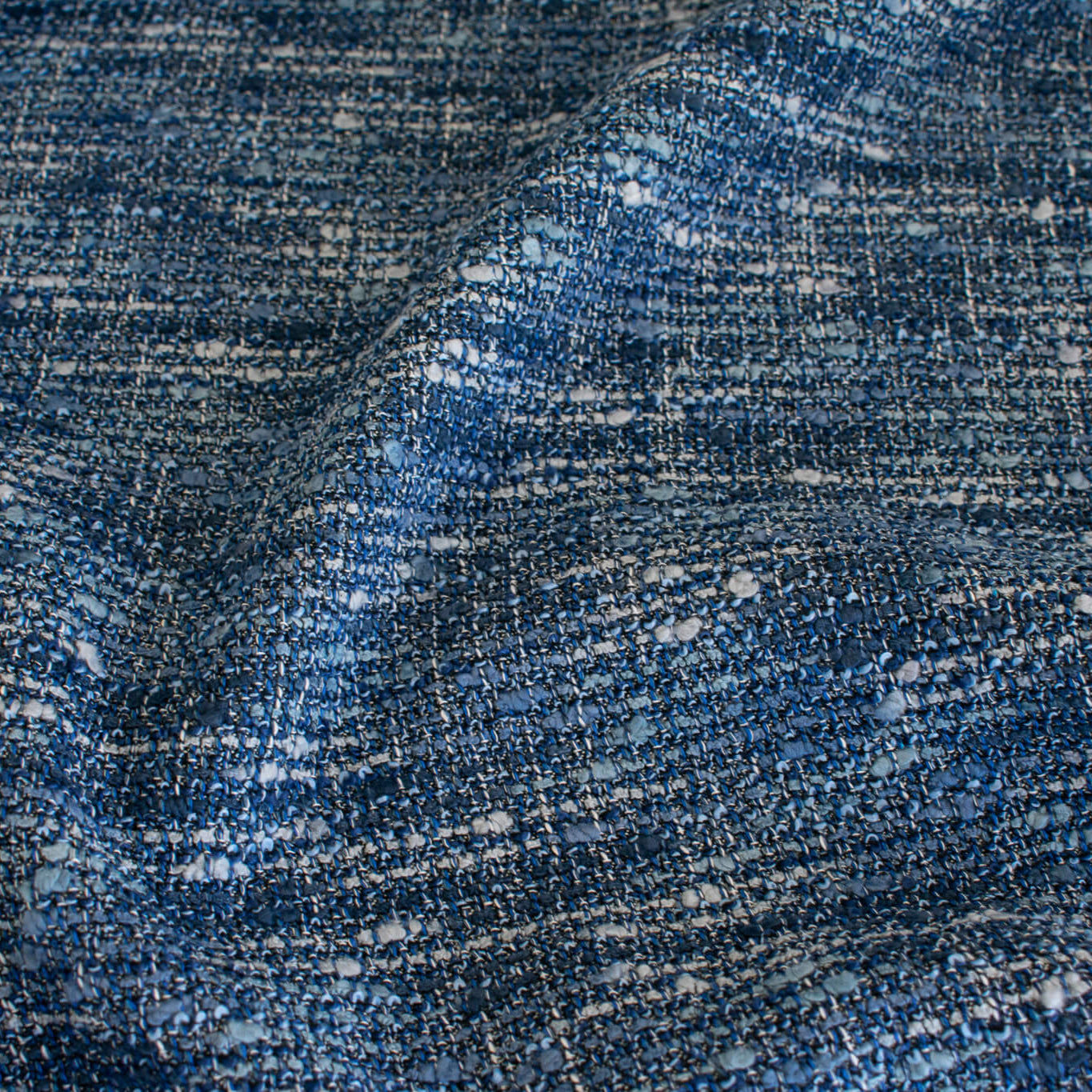 A beautifully soft NYC Designer Boucle suiting fabric by the yard that can be paired with sophisticated solids or your favorite denim. Varying shades of blue and alabaster yarns make this boucle extra special. Enjoy creating your next make with style and comfort. Image of fabric weave.