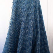 A beautifully soft NYC Designer Boucle suiting fabric by the yard that can be paired with sophisticated solids or your favorite denim. Varying shades of blue and alabaster yarns make this boucle extra special. Enjoy creating your next make with style and comfort. Image of fabric drape.