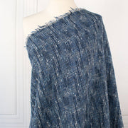 A beautifully soft NYC Designer Boucle suiting fabric by the yard that can be paired with sophisticated solids or your favorite denim. Varying shades of blue and alabaster yarns make this boucle extra special. Enjoy creating your next make with style and comfort. Image of fabric draped on dressform.