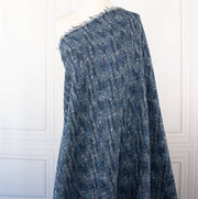 A beautifully soft NYC Designer Boucle suiting fabric by the yard that can be paired with sophisticated solids or your favorite denim. Varying shades of blue and alabaster yarns make this boucle extra special. Enjoy creating your next make with style and comfort. Image of fabric draped on dressform.