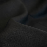 Italian, rich black 100% Linen fabric by the yard in a lovely mid-weight. The soft, crisp, and semi-textured hand of this fabric is perfect for creating sophisticated vests, dresses, suits, and skirts. This breathable fabric is perfect for warmer weather, making it a must-have for any fashion enthusiast. Close up image of fabric weave.