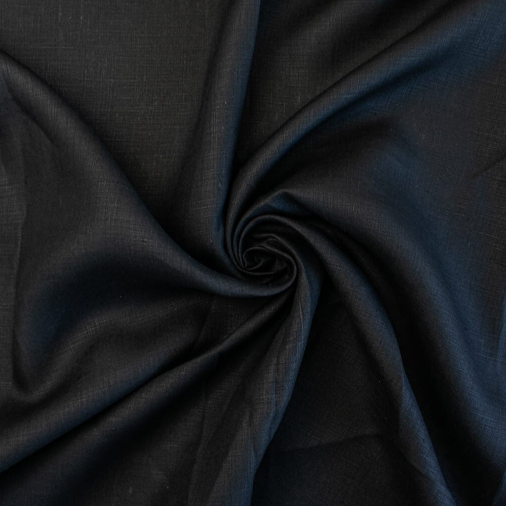 Italian, rich black 100% Linen fabric by the yard in a lovely mid-weight. The soft, crisp, and semi-textured hand of this fabric is perfect for creating sophisticated vests, dresses, suits, and skirts. This breathable fabric is perfect for warmer weather, making it a must-have for any fashion enthusiast. Image of fabric fullness.