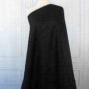 Italian, rich black 100% Linen fabric by the yard in a lovely mid-weight. The soft, crisp, and semi-textured hand of this fabric is perfect for creating sophisticated vests, dresses, suits, and skirts. This breathable fabric is perfect for warmer weather, making it a must-have for any fashion enthusiast. Image of fabric on dressform.