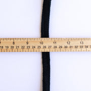 Vintage Foldover Black Braid Trim is back! This soft 1 inch trim can be folded to a sleek half-inch, perfect for a clean final touch on garment edges. Image of trim folded with ruler demonstrating trim width.