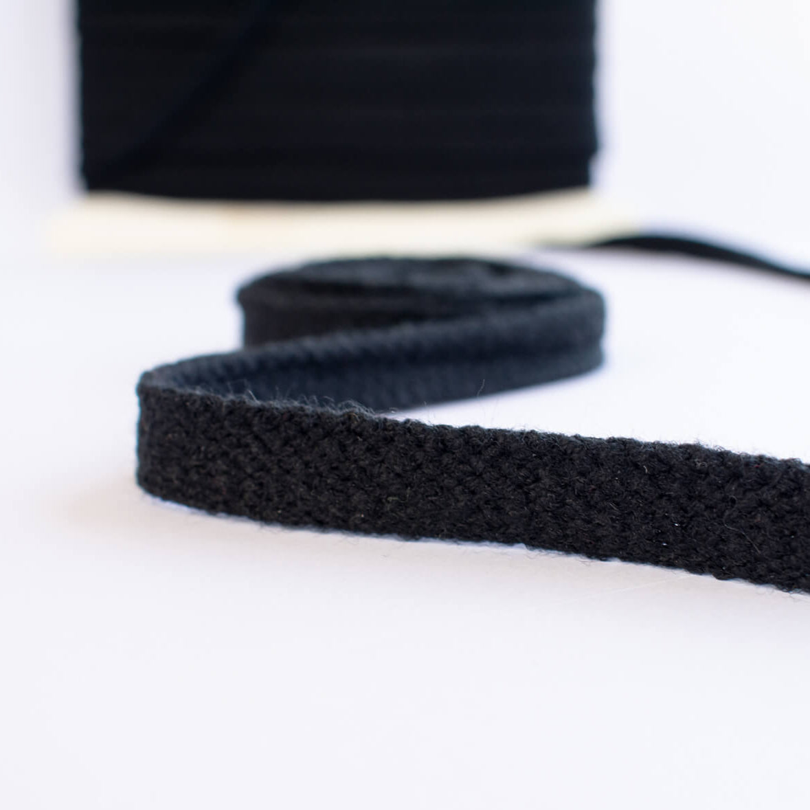 Vintage Foldover Black Braid Trim is back! This soft 1 inch trim can be folded to a sleek half-inch, perfect for a clean final touch on garment edges. Close up image.