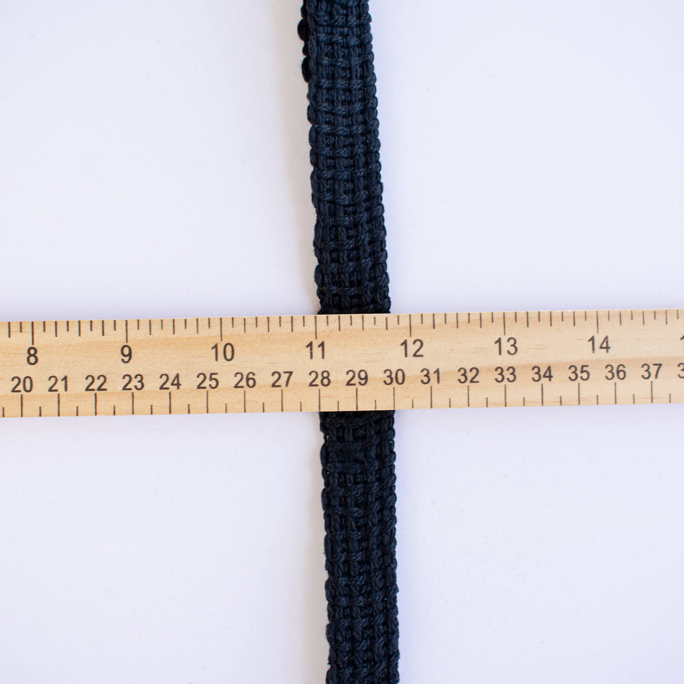 Vintage Foldover Black Braid Cotton Trim is back! This 1 and one-half inch trim can be folded to a sleek five-eighths of an inch creating a perfect clean finish for your sewing project. It also looks gorgeous as a base trim when layering trims for a designer look. Image of folder trim and ruler to show width.