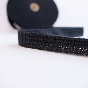 Vintage Foldover Black Braid Cotton Trim is back! This 1 and one-half inch trim can be folded to a sleek five-eighths of an inch creating a perfect clean finish for your sewing project. It also looks gorgeous as a base trim when layering trims for a designer look. Close up image of trim design.
