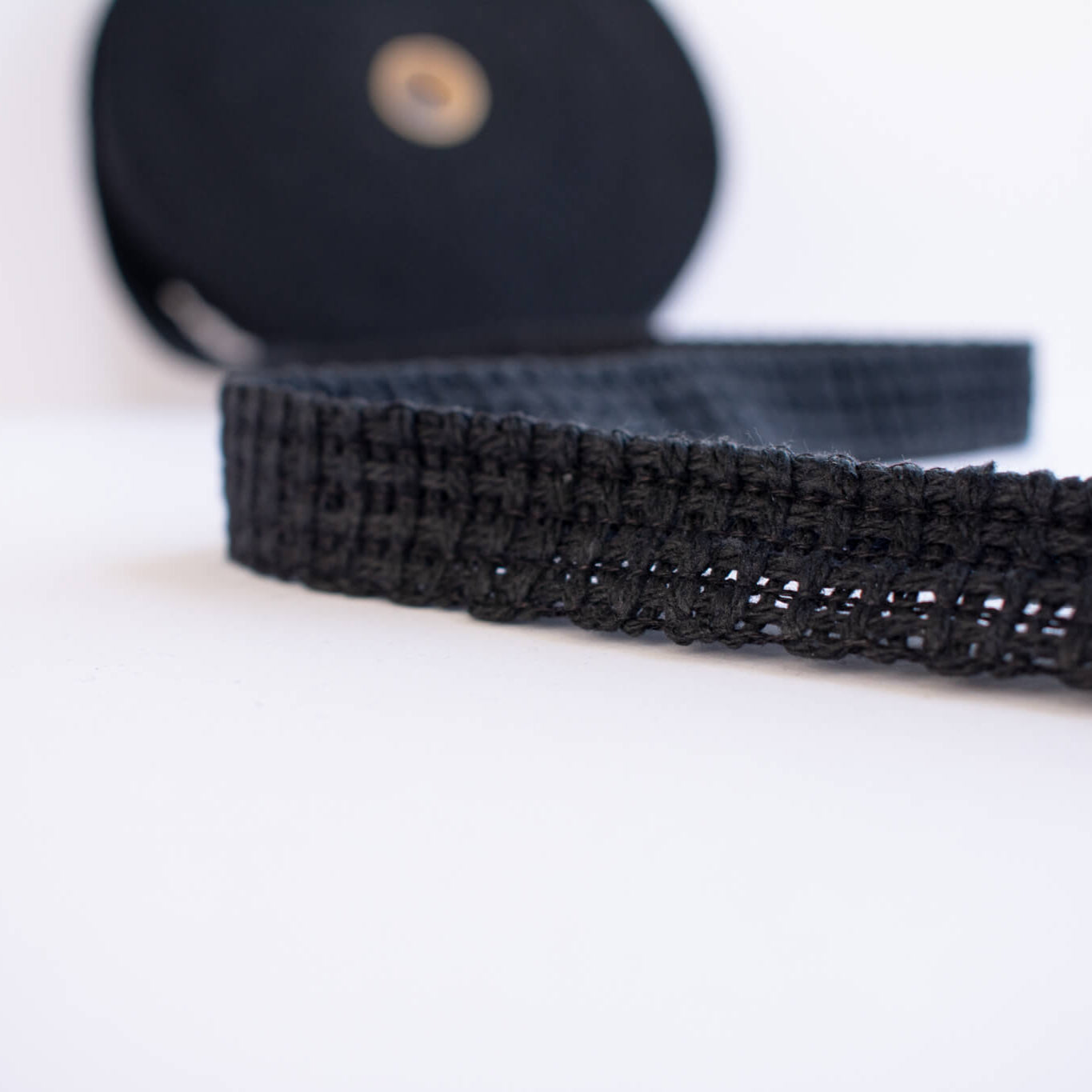 Vintage Foldover Black Braid Cotton Trim is back! This 1 and one-half inch trim can be folded to a sleek five-eighths of an inch creating a perfect clean finish for your sewing project. It also looks gorgeous as a base trim when layering trims for a designer look. Close up image of trim design.