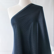 Image of fabric draped on dressform. A gorgeous wool blend suiting from a Beverly Hills couture house is sure to add glamour to your outfit!  A soft textured hand with a herringbone stripe pattern that shimmers with silvery metallic threads. A perfect choice for ;a jacket, skirt, wide leg pant, or perhaps a coat dress.