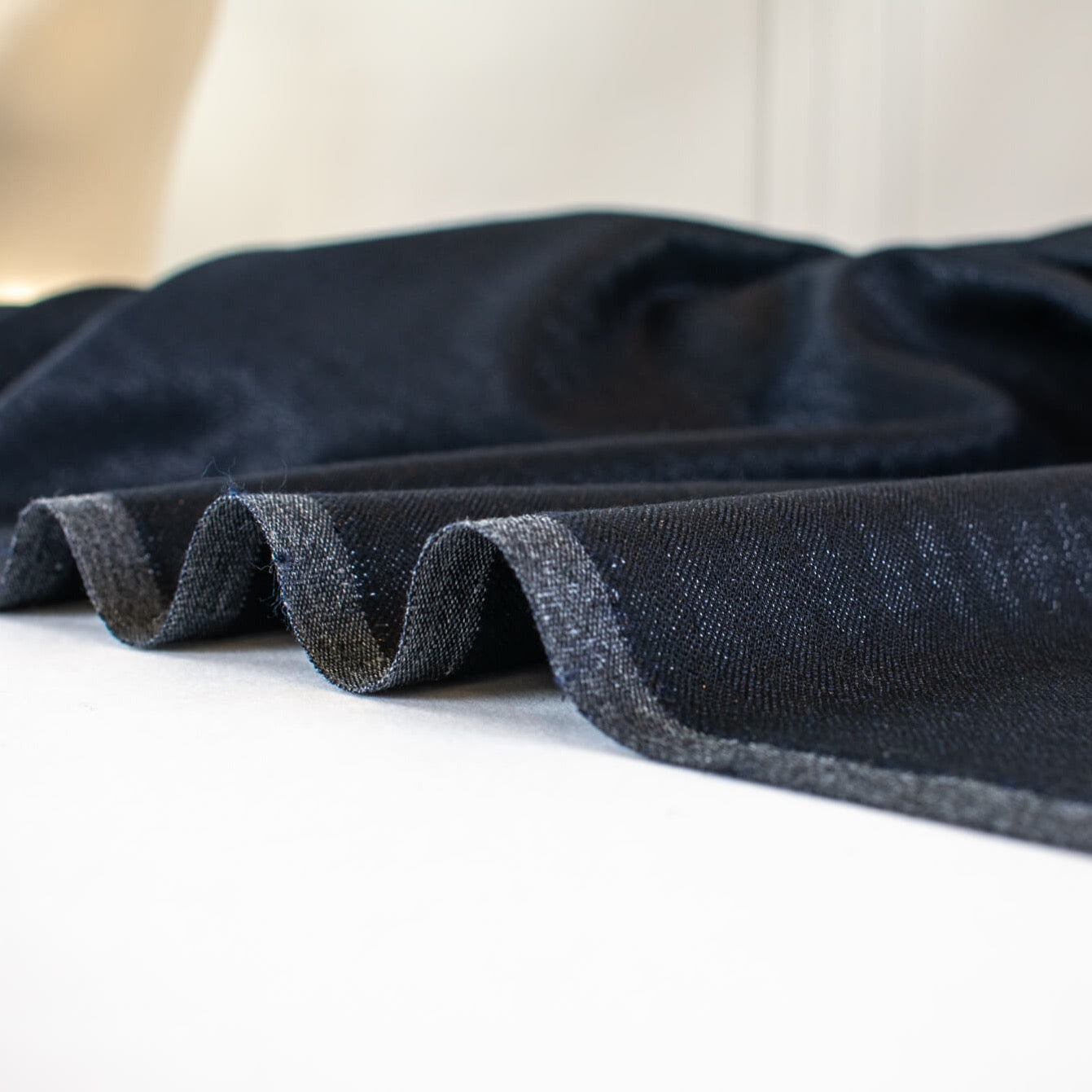 Image of selvedge. A gorgeous wool blend suiting from a Beverly Hills couture house is sure to add glamour to your outfit!  A soft textured hand with a herringbone stripe pattern that shimmers with silvery metallic threads. A perfect choice for a jacket, skirt, wide leg pant, or perhaps a coat dress.