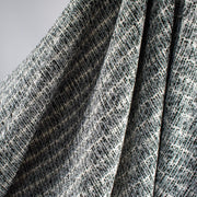 Close up of black and white jacquard fabric by the yard. Subtle silver metallic threads through out this wool blend suiting. Imported from France. Perfect for that Classic French Jacket! - image shows fabric drape