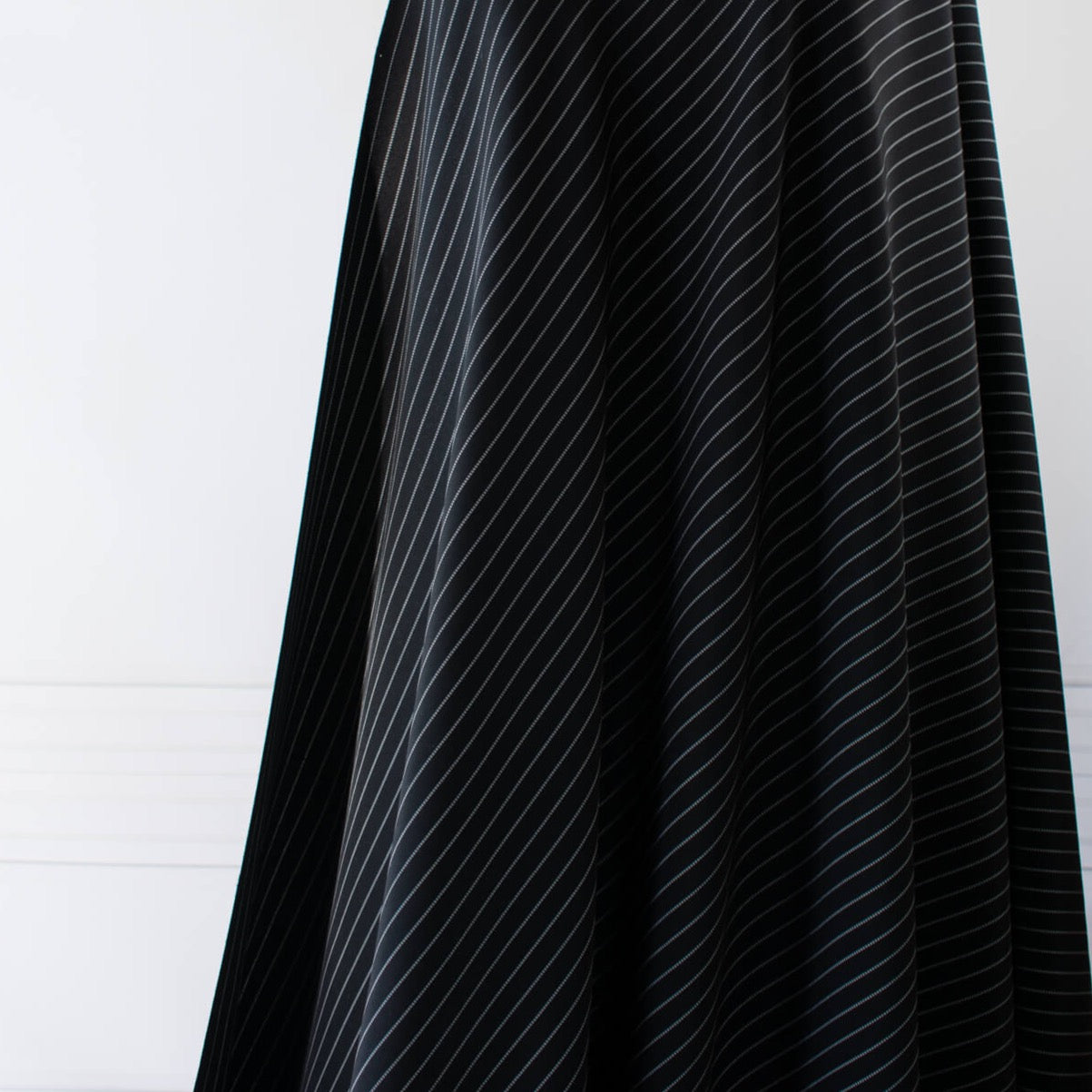 Gorgeous Couture Designer 4-Ply Silk Black with a white vertical double pinstripe, this premium medium weight silk has a soft sheen and gentle drape. A fine smooth hand feels buttery on the skin, perfect for a wide leg pant, vest, jacket or dress! Image of fabric drape.