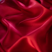 Enjoy the luxury of stretch silk charmeuse in scarlet. Designer deadstock originally from a New York couture designer! You can enjoy the silkiness of a 96 % silk and 4% lycra in a easy to work with 54 inch width for one of your fancy frocks. A popular fabric for creating fluid bias cut garments and luxurious lining to your special pieces like the French Jacket. Close up photo of fabric luster.