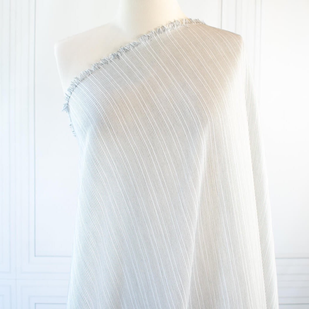 Light and airy Italian voile is soft and ohh so summery! Can you just picture yourself in a loose fitted unbuttoned shirtdress as a gorgeous layering piece over a cami and ankle length jeans. This will definitely take your summer holiday up a notch! Perfect for summer dresses, skirts and tops. The thin horizontal black stripes and bright white woven opaque stripes are set against a sheer white voile. Fabric on dress form.